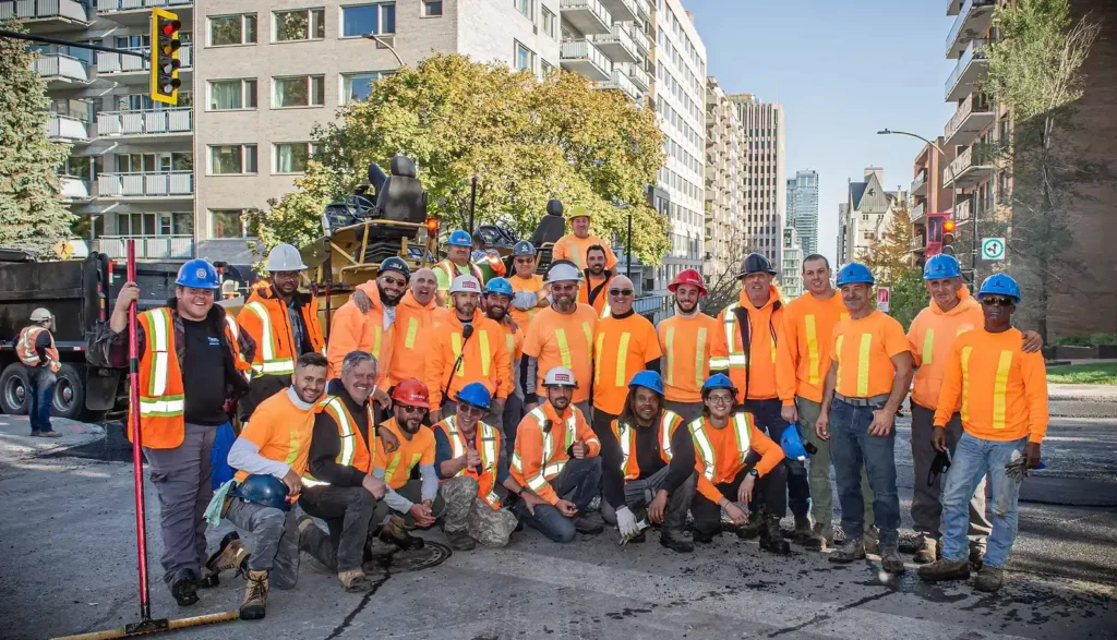 Groupe de 25 travailleurs de la construction prenant la pose.